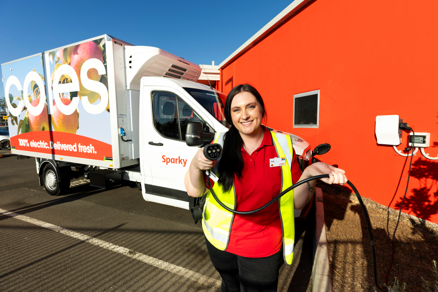 Coles team member with EV delivery van
