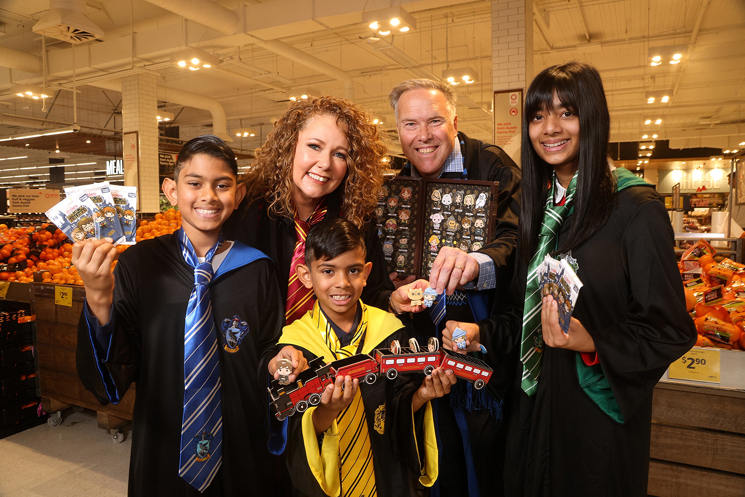 Coles CMO Lisa Ronson, Warner Bros. Consumer Products Vice President Andrew Bromell and Quade, Kynan and Escada with Coles’ new collectables, Coles Magical Builders