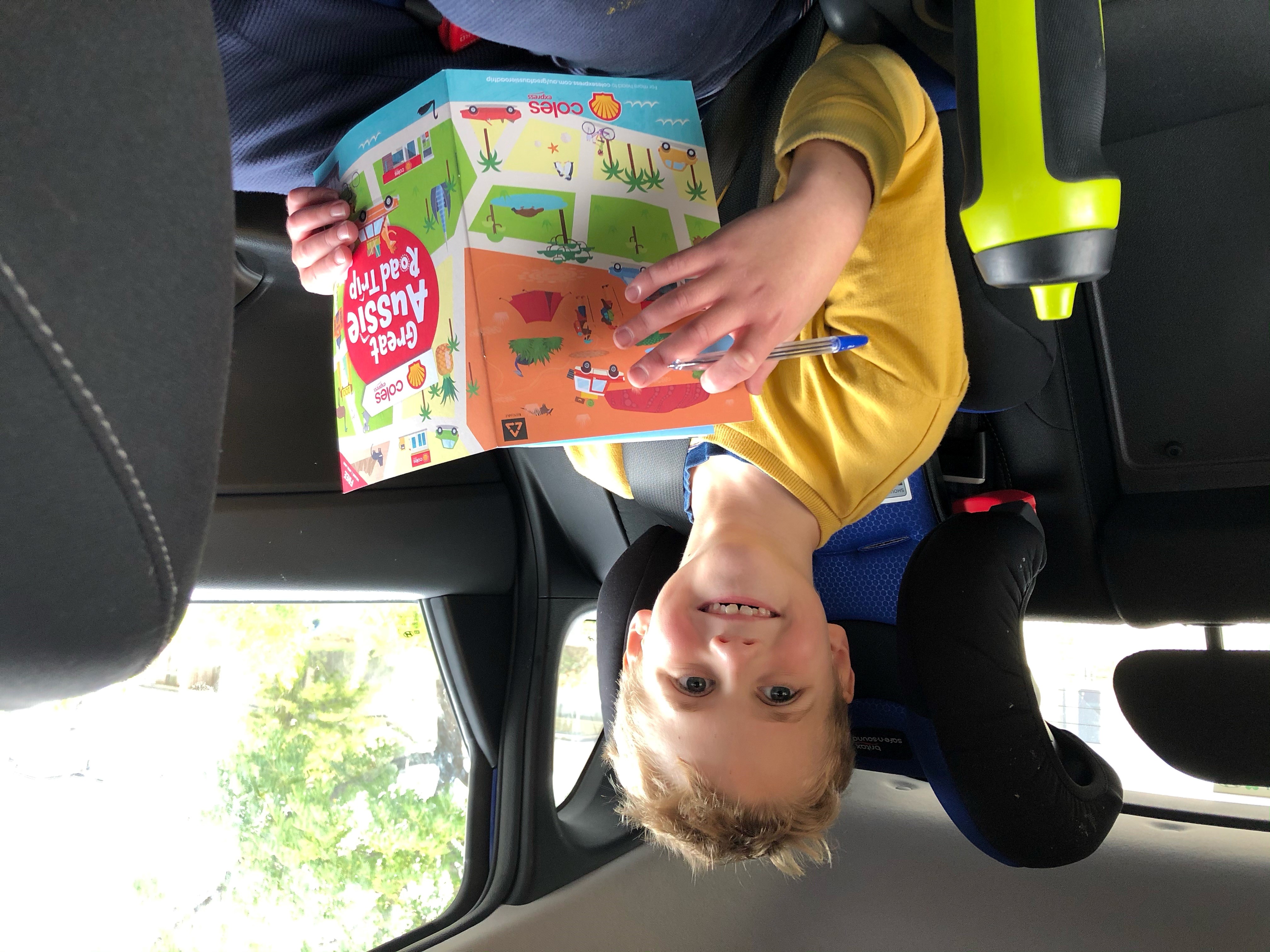 Eight year old Zach enjoys playing with his Great Aussie Road Trip booklet and collectable stickers on a long drive