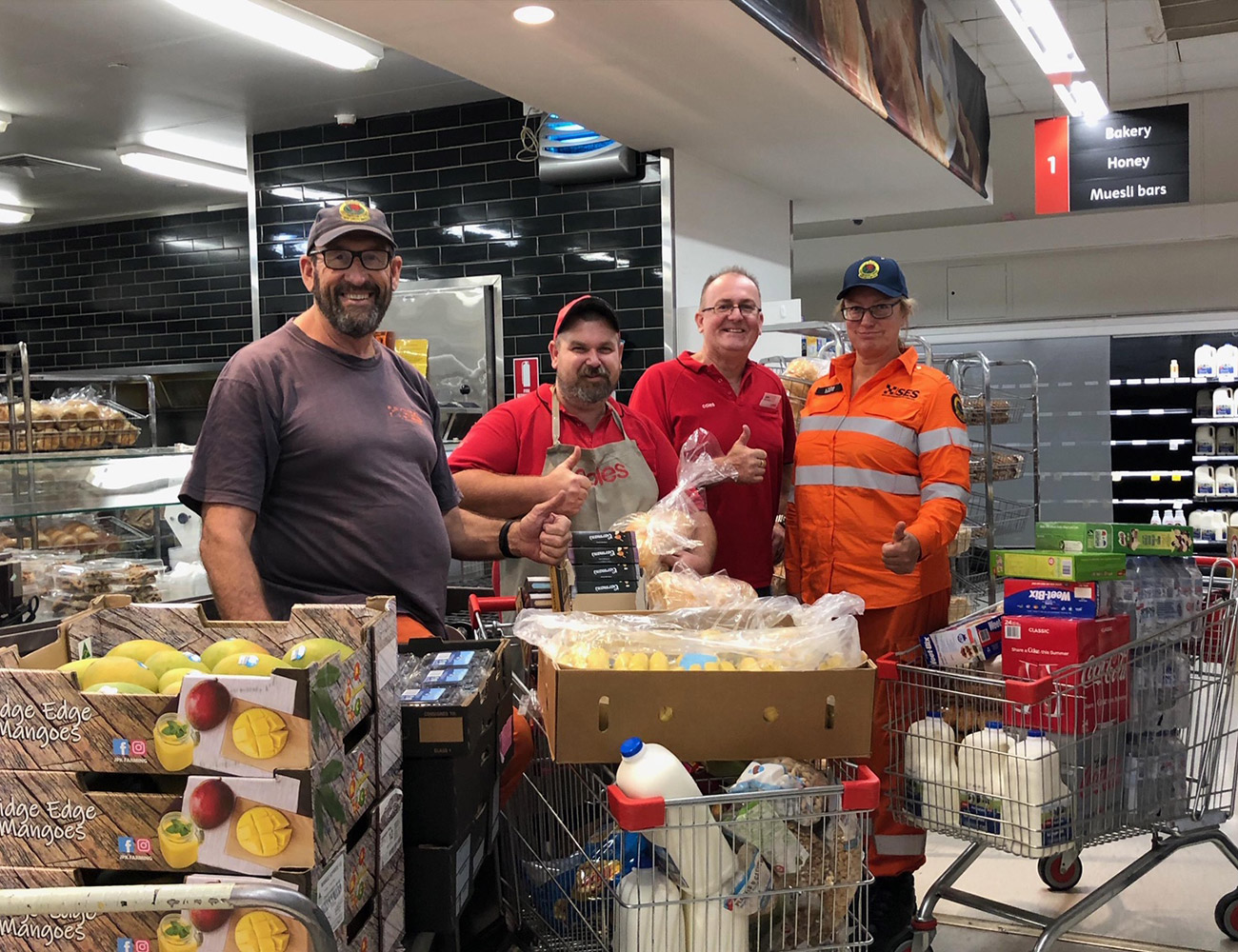 RFS fireys with Coles Batemans Bay team members receiving donations of full trolleys of groceries and fresh produce